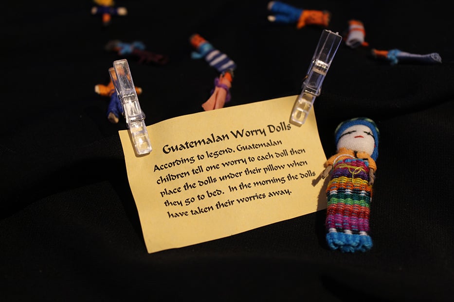 Text Reads: Guatemalan Worry Dolls. According to legend, Guatemalan children tell one worry to each doll then place the dolls under their pillows when they go to bed. In the morning, the dolls have they taken their worries away. 