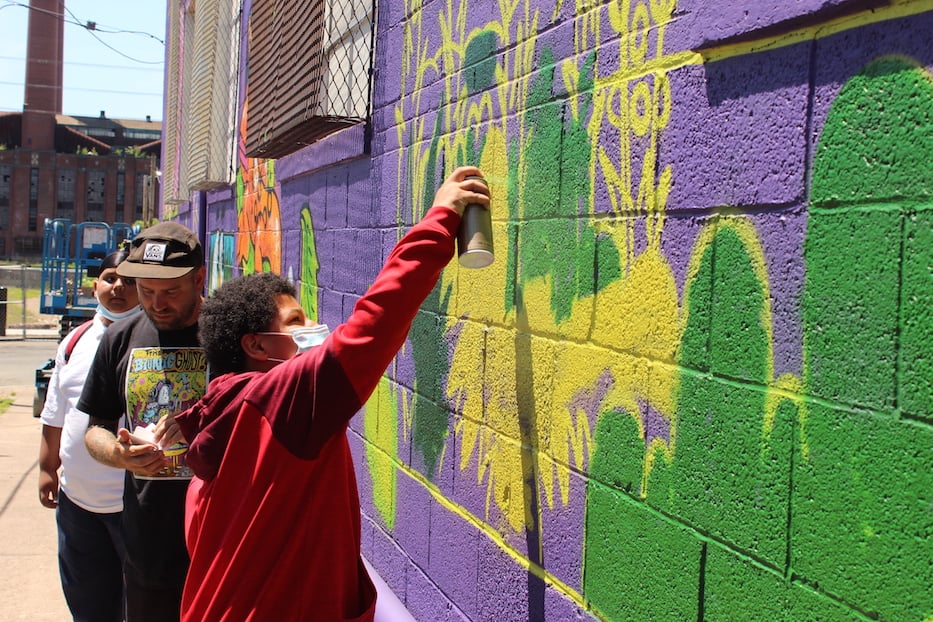 A student takes a turn at the mural