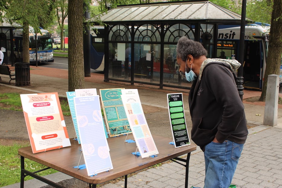 A New Havener walks by to read the poster boards