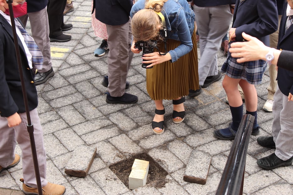 Students gather around the witness stones