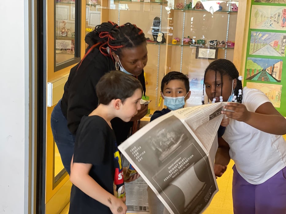 Students gather around Principal Sabrina Breland to admire the latest issue of the East Rock Record