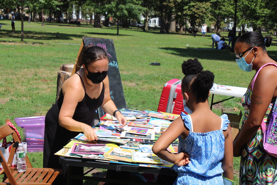 Jennifer Heikkila Díaz helps a family pick out books