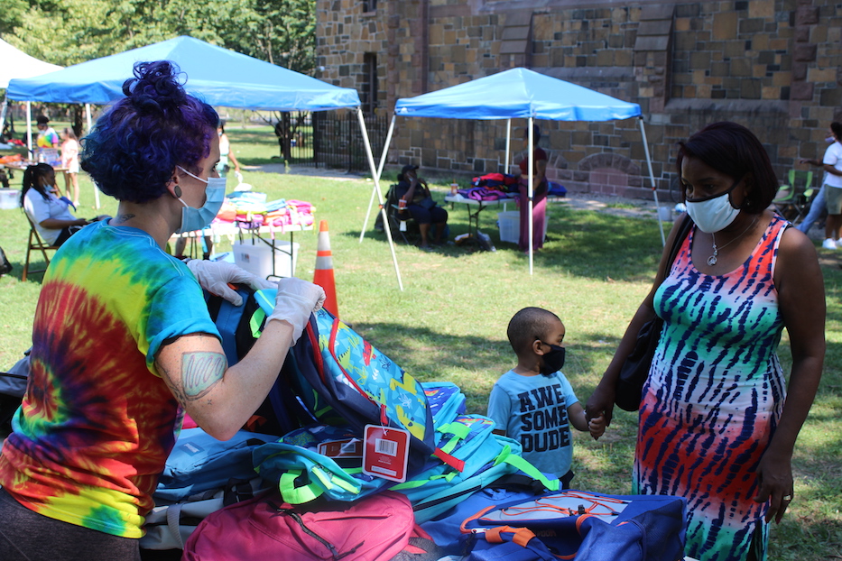 Sarah Fritchey helping people pick out a bookbag