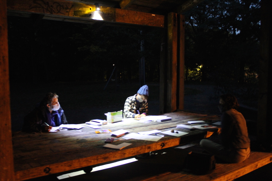 The group works under a bike light attached to the rafter