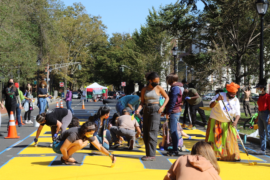 Volunteers painting the second word of the mural