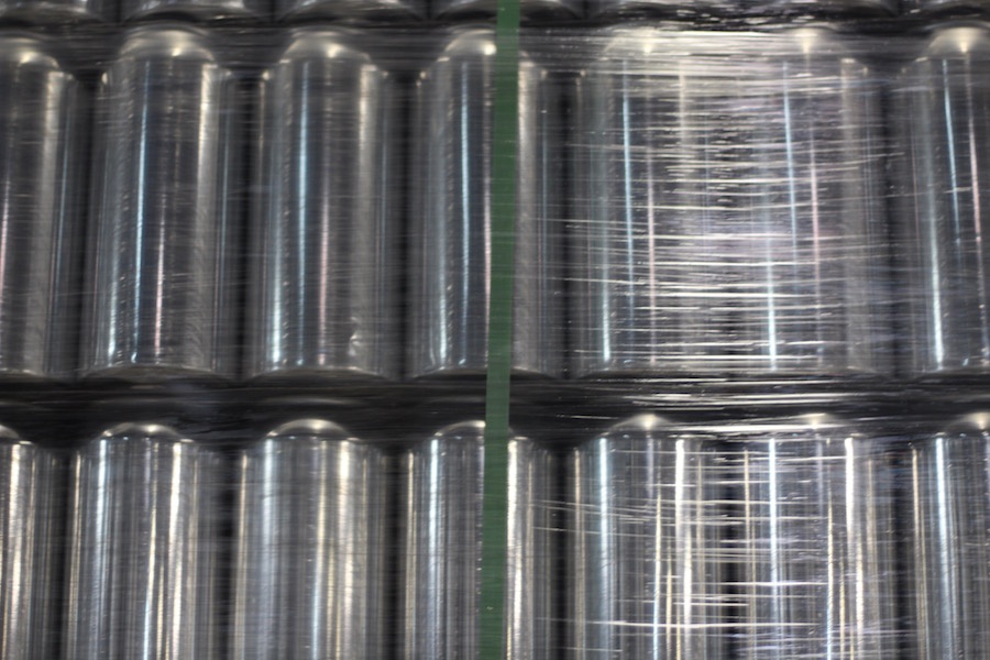  In the brew space, ceiling-high crates of cans wait to be filled.  