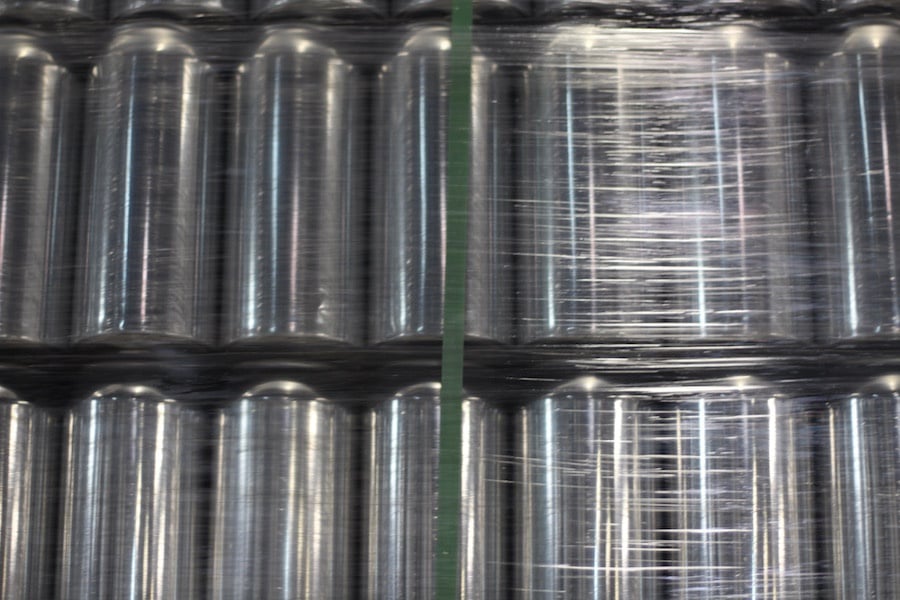 In the brew space, ceiling-high crates of cans wait to be filled.