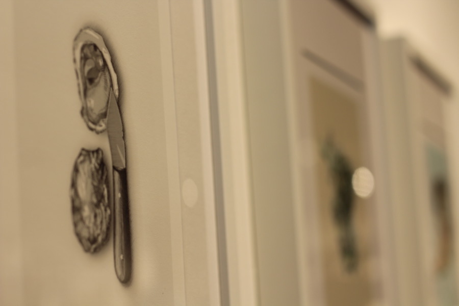 Kevin Cimo’s work, which is displayed with beer cans neatly placed beneath each frame.