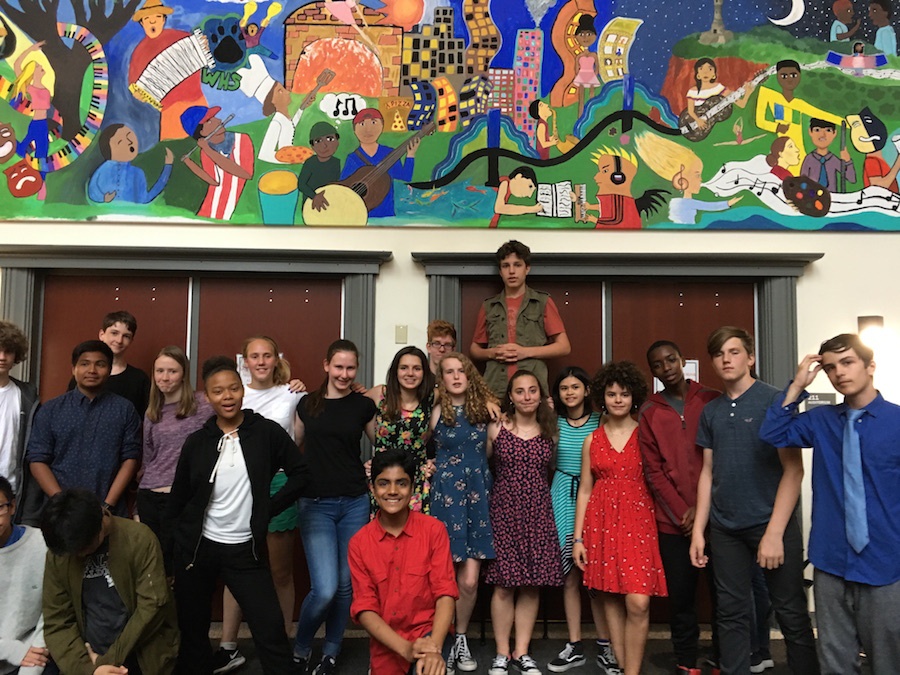 Almost all of the students in Hooker's eighth grade class gather beneath the mural.