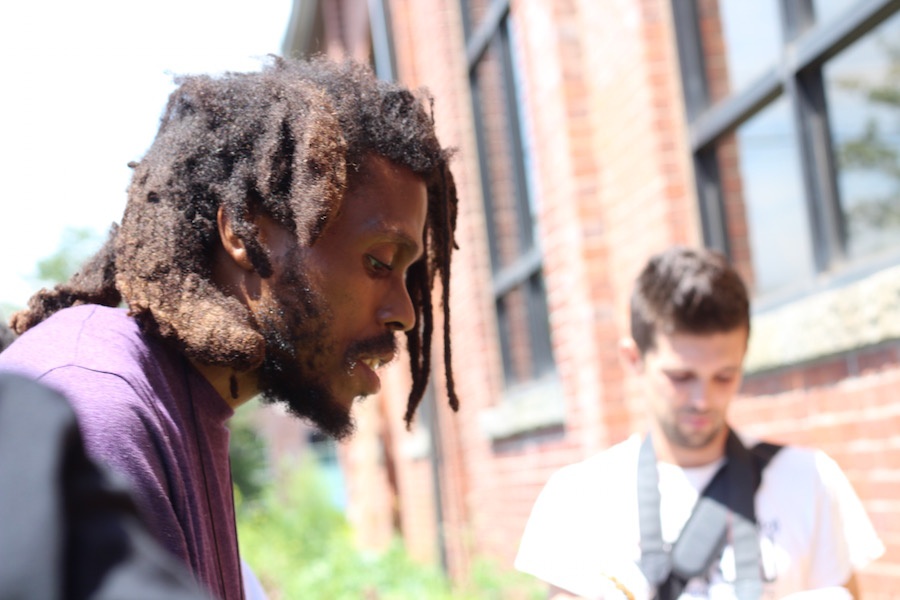 New Havener Dishaun Harris, co-founder of Love Fed New Haven with Raven Blake, describes the raised beds to Lamont.