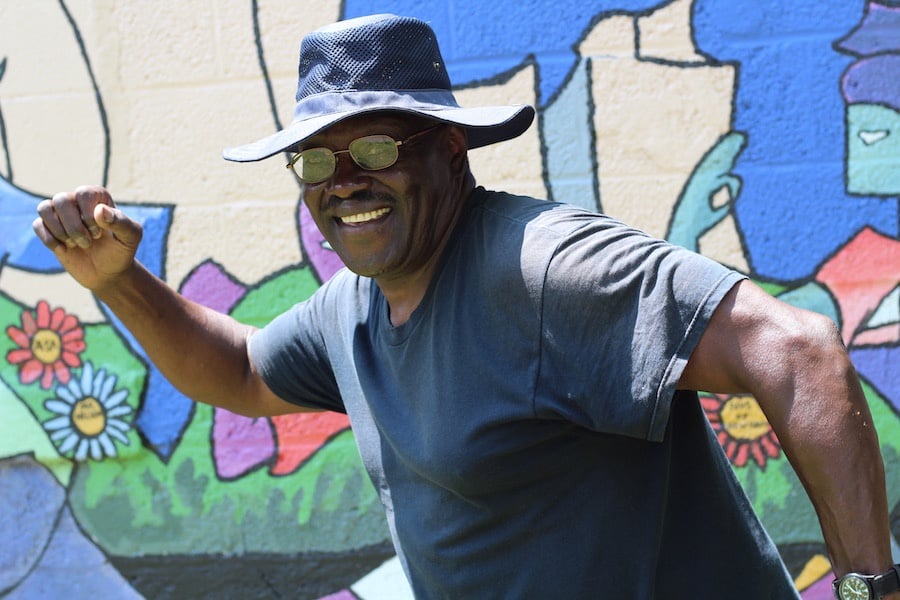 “From morning to night, I hear people on the trail” Calvin Nelson said. The Elm City Footraces mural is on the side of his garage. “I love it.” 