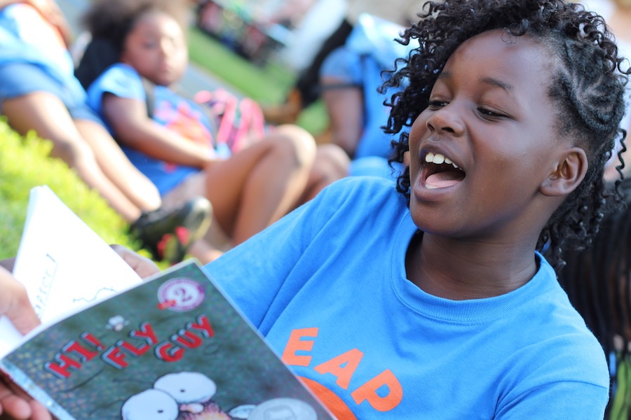 Eight year old Serenity Lewis dives into a book from Tedd Arnold's