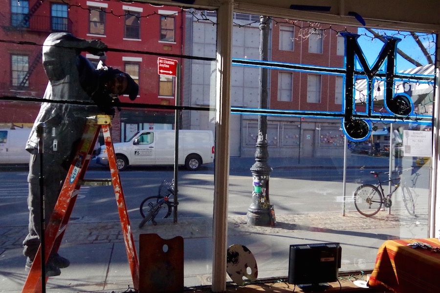Artist Amen Ra puts the final touches on the pop-up. Lucy Gellman Photo.