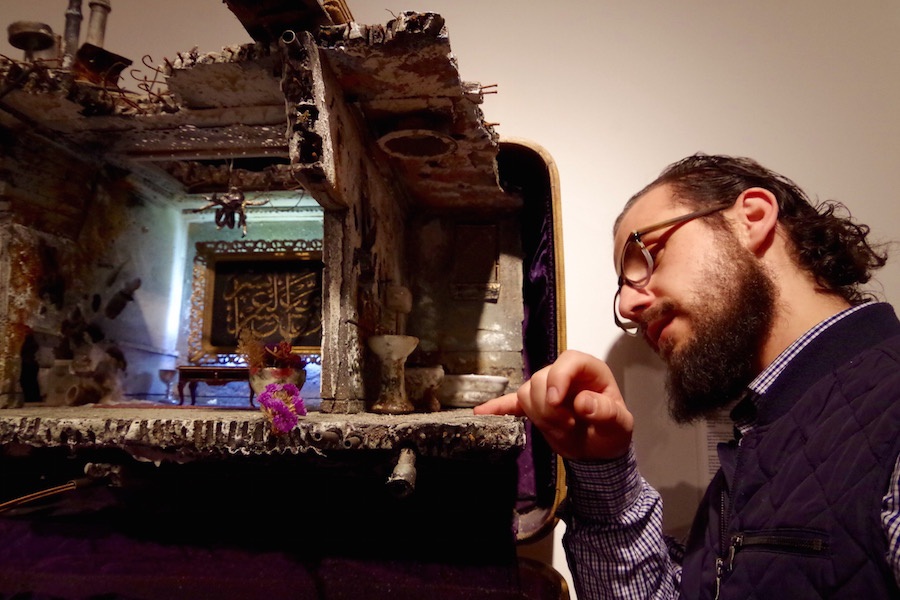 Before Monday's reception, Hafez took moments to examine each piece. Here, he pointd to where water should line the floor in Badr's miniature. Lucy Gellman Photo.
