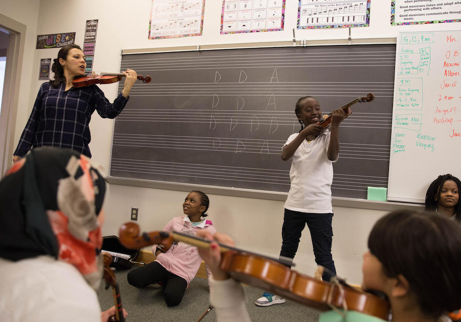  Yaira Matyakubova teaches a violin class for refugee children at Music Haven in New Haven, Conn. Photo by Ryan Caron King for WNPR. 