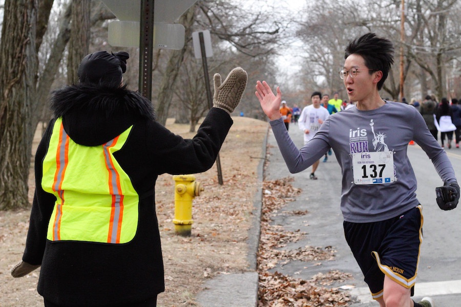  Runner Dennis Wang, a student at the Yale School of Medicine and graduate of the Yale School of Public Health, hits the three mile mark, and gets some support from a race volunteer.  